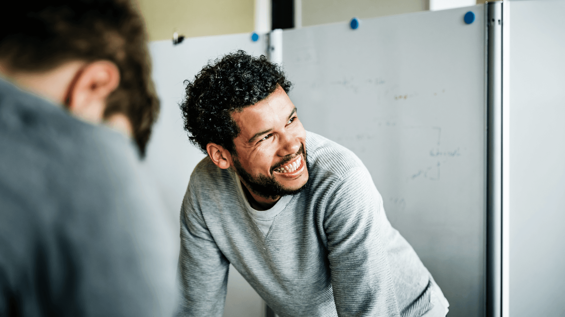 Portrait of casual businessman during meeting smiling to his colleague off camera