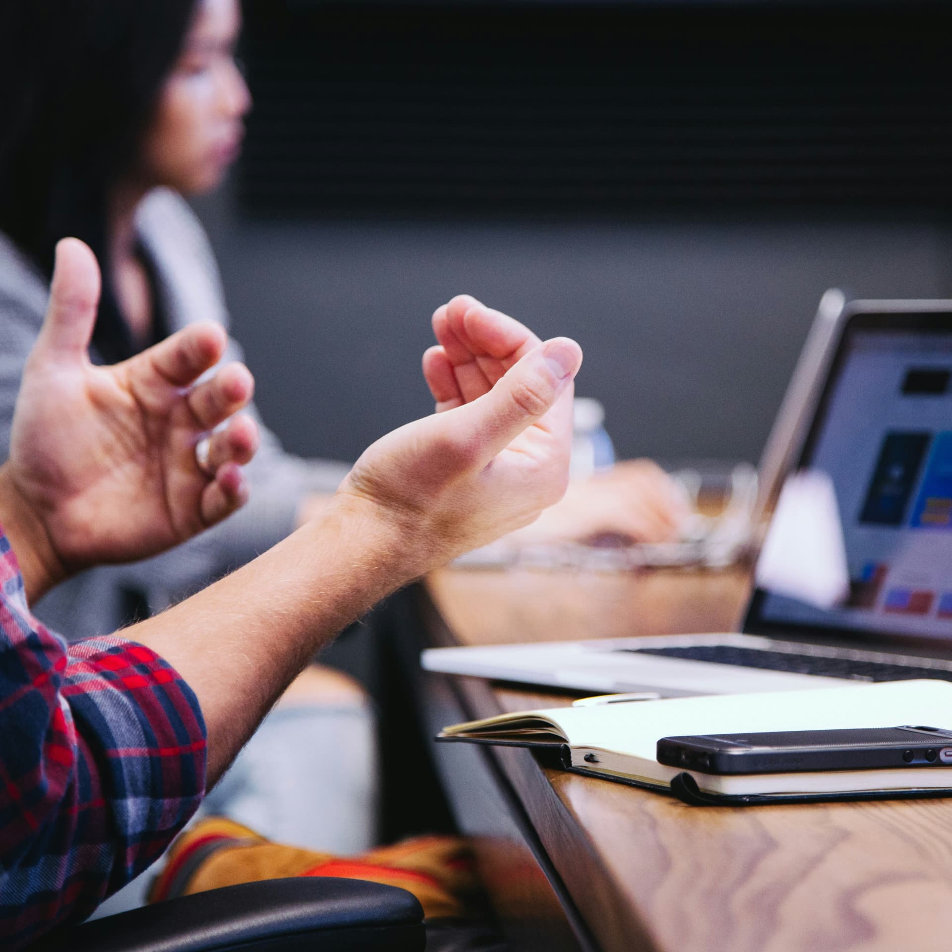 Close up hands gesturing at a laptop screen