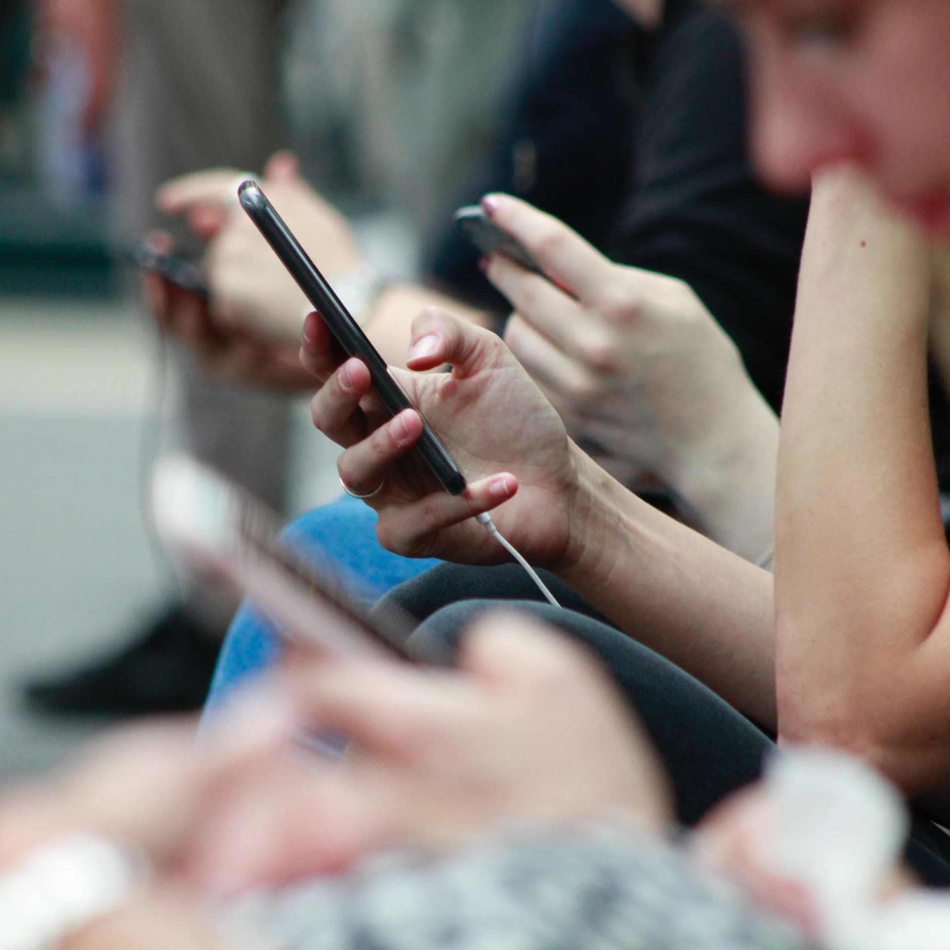 Close up of people holding mobile phones in hands