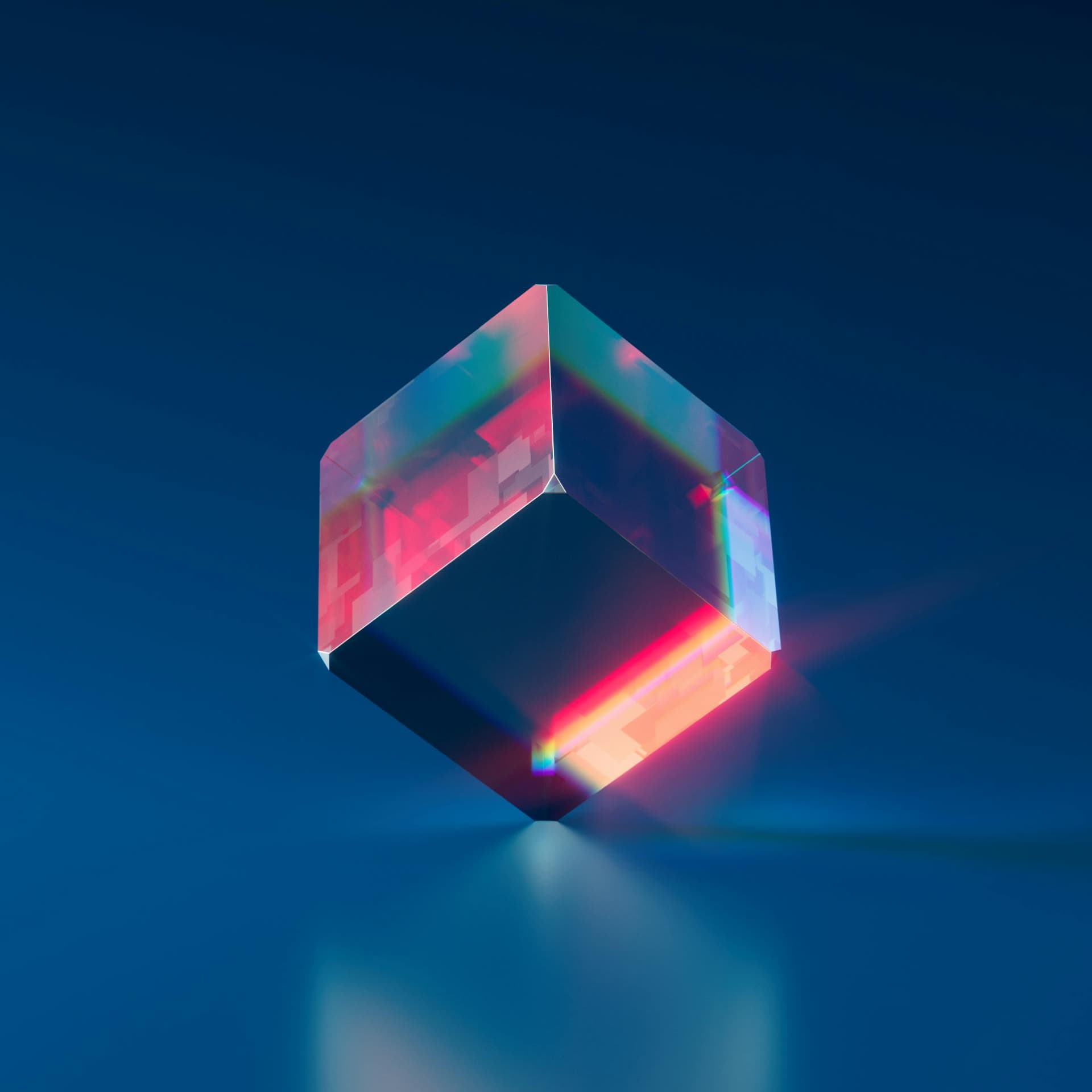 Digital generated image of a glass cube against a blue background with red light shining through it