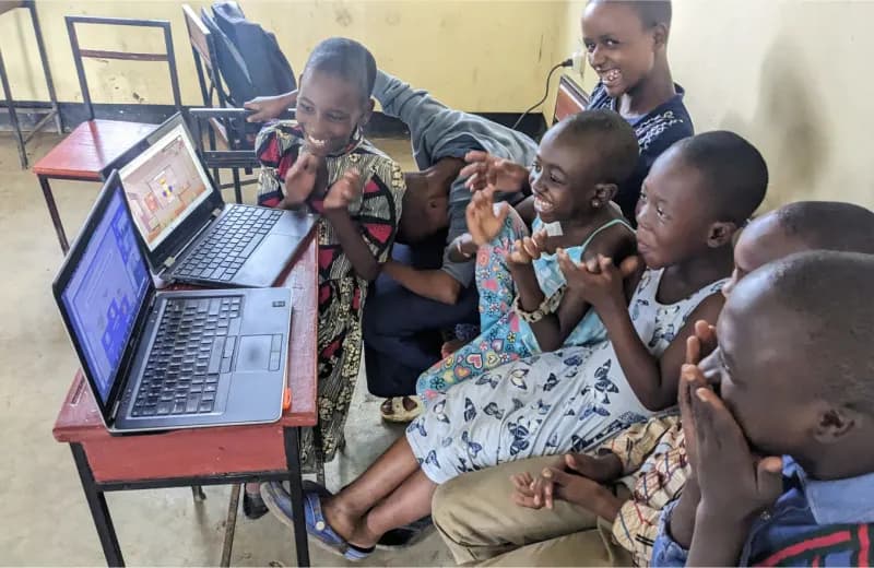 Kids gathered around computers learning