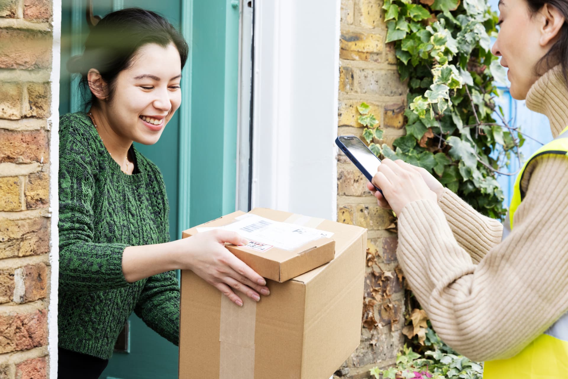 Courier photographs parcels delivered to door, held by recipient