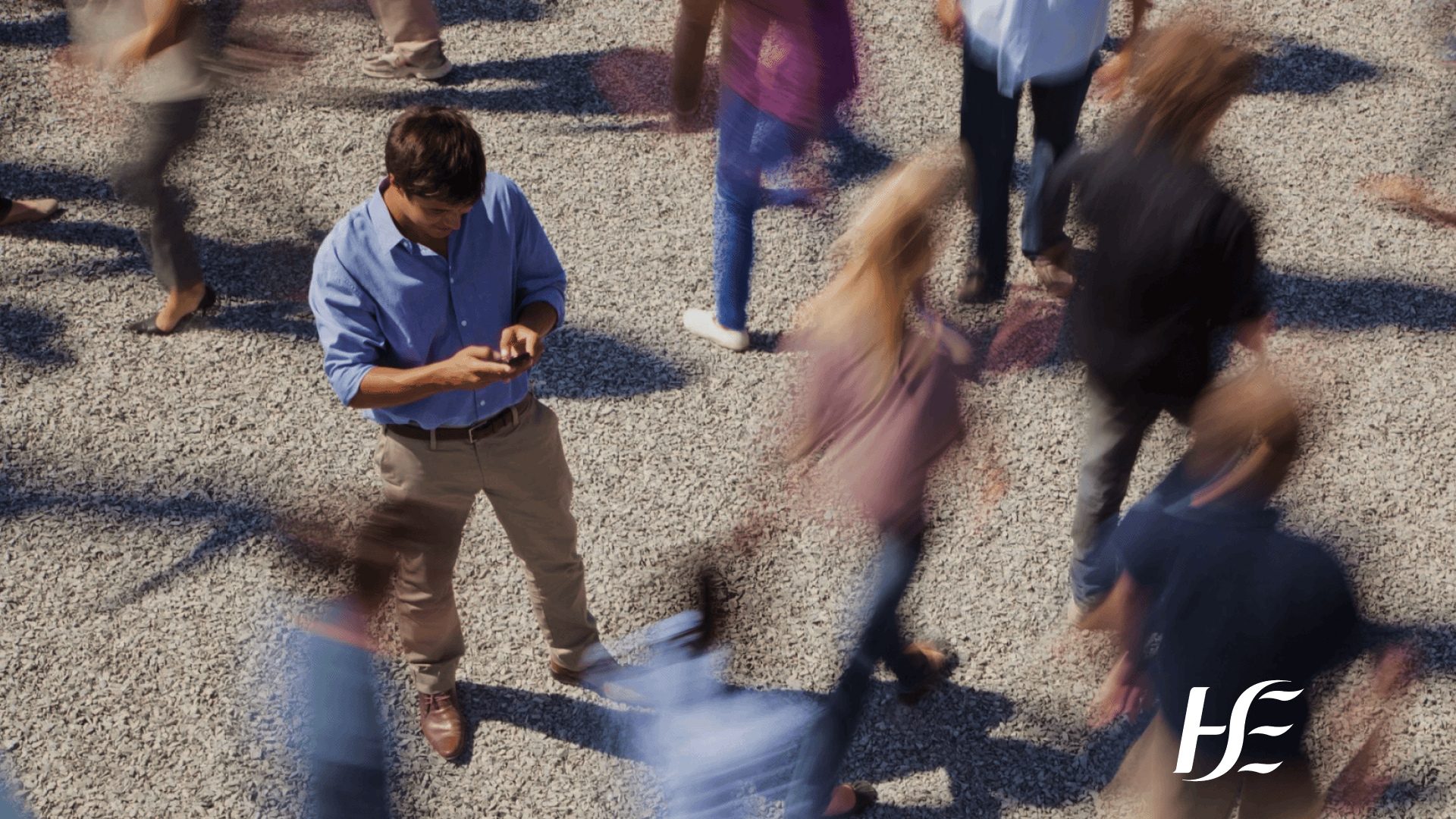 Health Service Executive - A man using his phone among a crowd