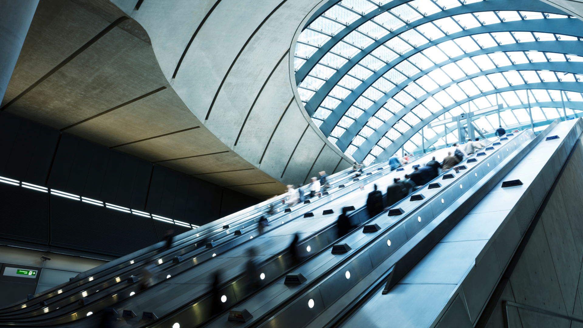 Customer Story: Management consultancy - Commuters on escalators at Canary Wharf Subway Station, financial district, UK