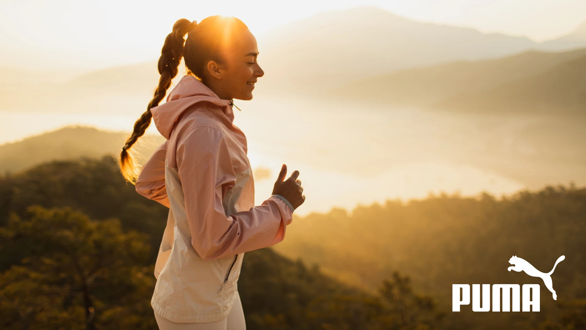 Puma - Happy young woman running outdoors with mountain view at sunset