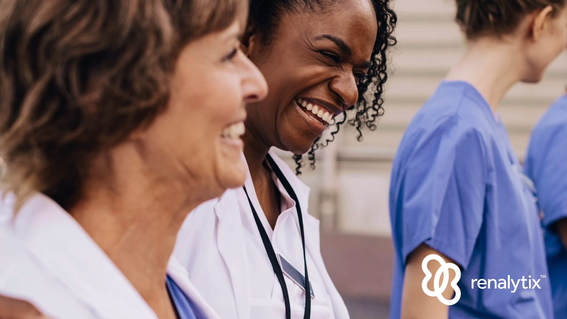 Renalytix - Happy female physician with arm around colleague outside hospital