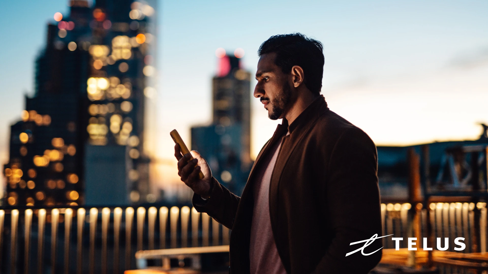 Telus - A businessman uses a mobile phone on a rooftop